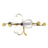 An early 20th century gold moonstone and ruby floral brooch.
