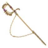 An early 20th century gold ruby and split pearl sword jabot pin.