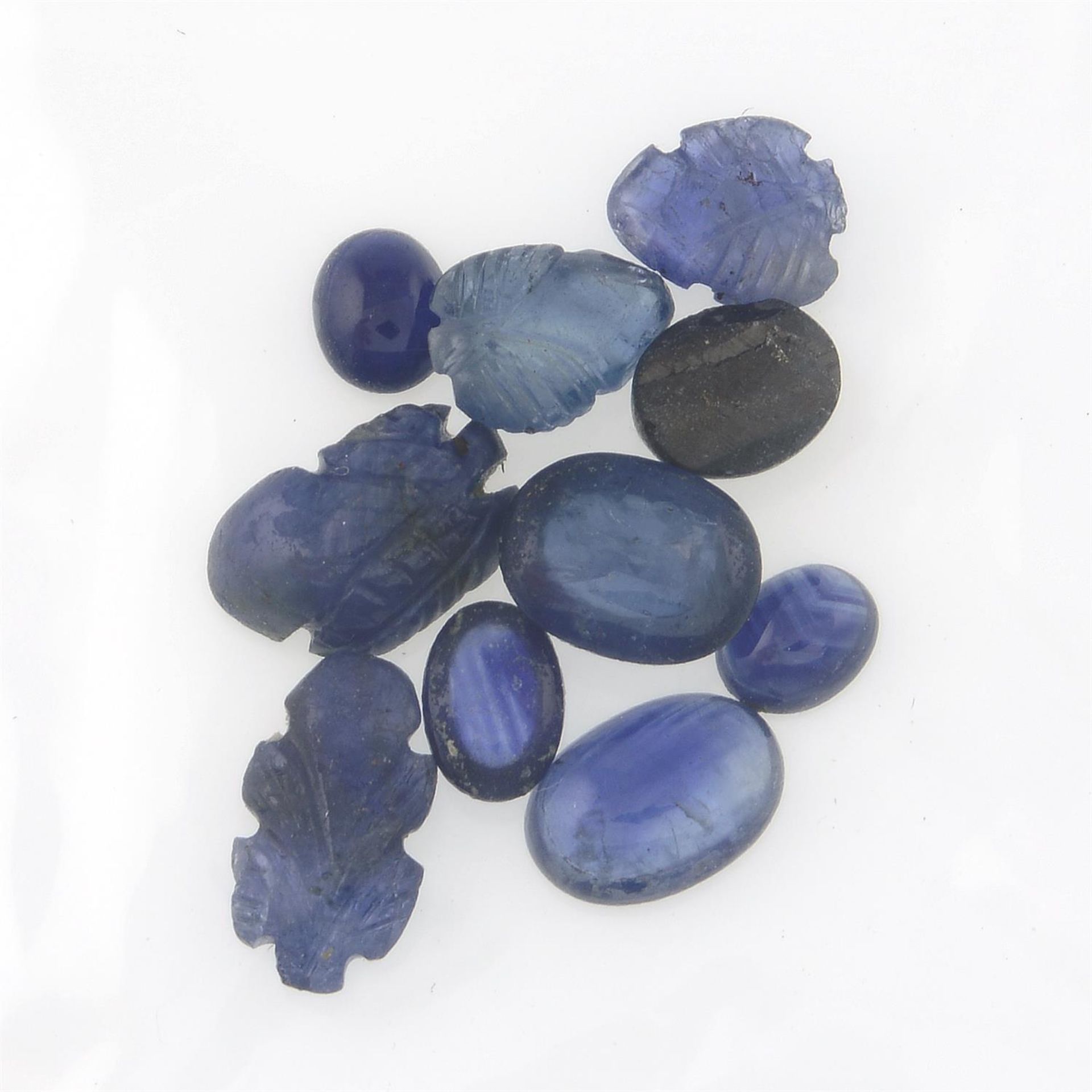 A selection of carved sapphires and oval sapphire cabochons, total weight 24.87cts. - Image 2 of 2