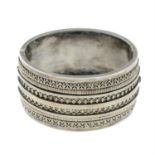 A late Victorian silver hinge bangle with ornate appliqué front.