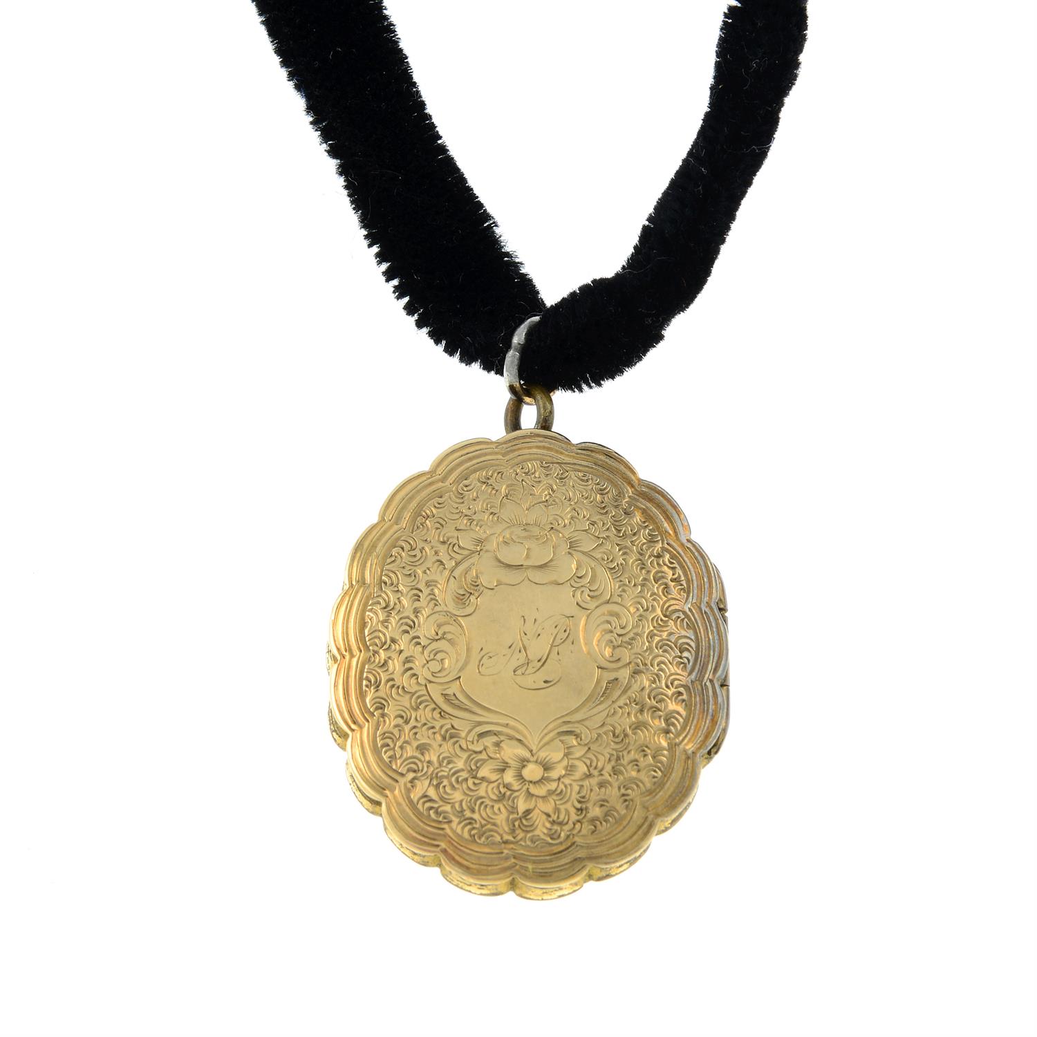 A late Victorian engraved locket, with a velvet cord.