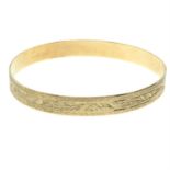 A 9ct gold engraved bangle.