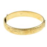 A 9ct gold engraved hinge bangle hinged with plain reverse.