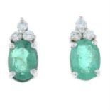 A pair of emerald and diamond earrings.