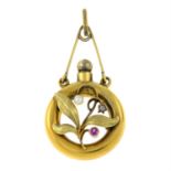 An Art Nouveau 15ct gold ruby, diamond and seed pearl foliate pendant, depicting a perfume bottle.