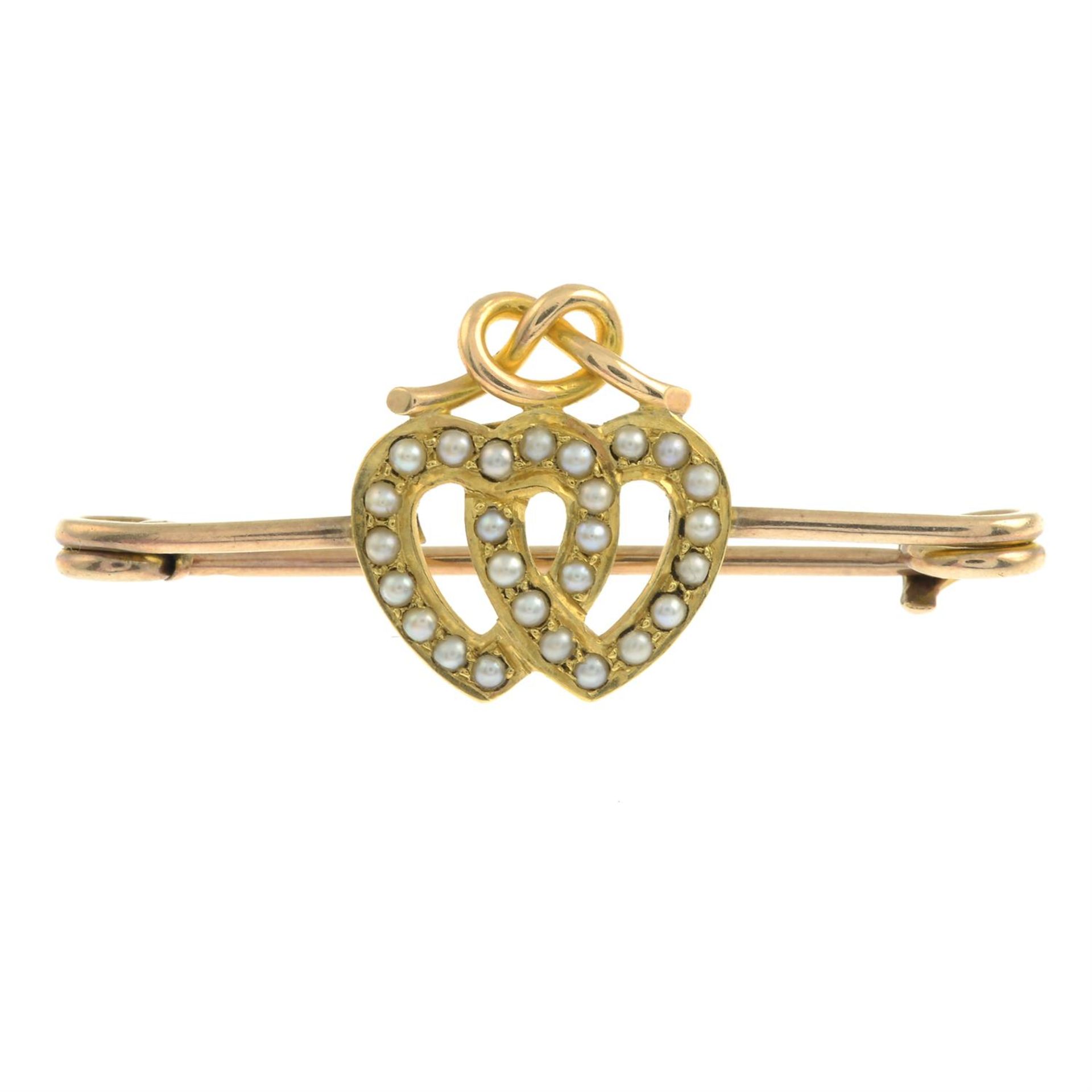 An early 20th century gold split pearl double heart bar brooch.