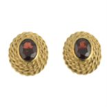 A pair of garnet single-stone earrings.