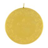 A foliate embossed coin pendant.