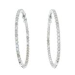 A pair of diamond hoop earrings.