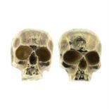 A pair of skull stud earrings.