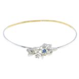 A child's 9ct gold bangle, with diamond and blue gem accent floral motif.