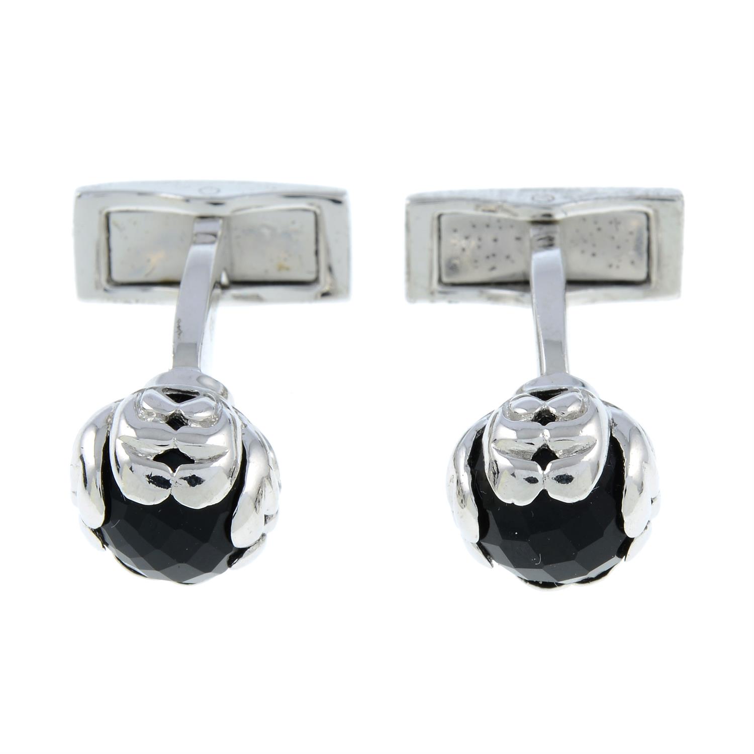 A pair of silver floral cufflinks, each with black gem accent, by P. D. Man.