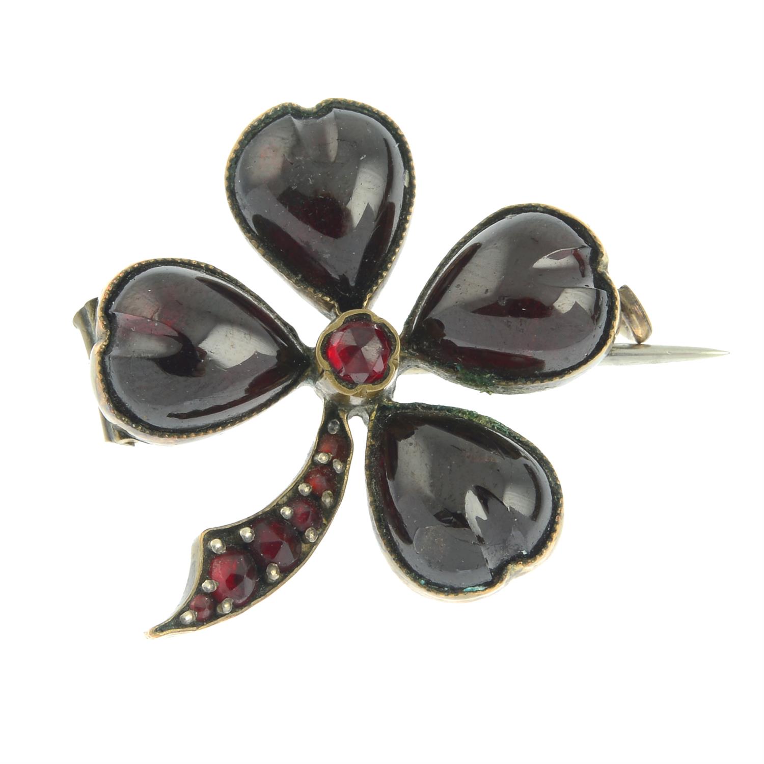 A late 19th century garnet four-leaf clover brooch.