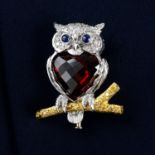 An 18ct gold diamond and garnet owl brooch, with sapphire eyes, perched on a 'yellow' diamond