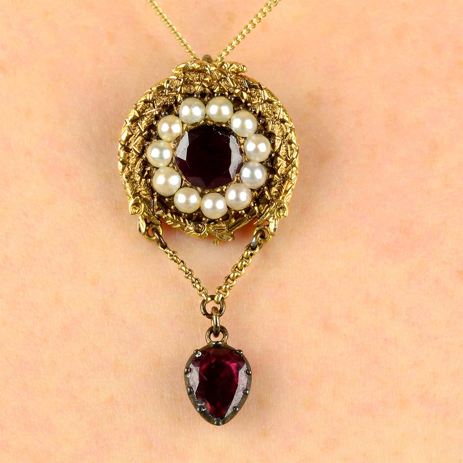 A Georgian, gold foil back garnet and split pearl ouroboros snake pendant.