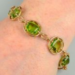 An Edwardian 15ct gold vari-shape peridot bracelet, with modified kite-shape peridot drop.