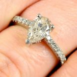 A pear-shape diamond ring, with diamond set shoulders.