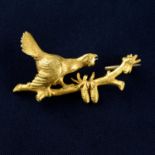 A late 19th century gold brooch, depicting a bird upon a branch.