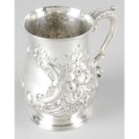 A mid-Victorian silver baluster mug with repoussé flowers and scrolls.