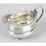 A George IV silver cream jug with gadrooned rim.
