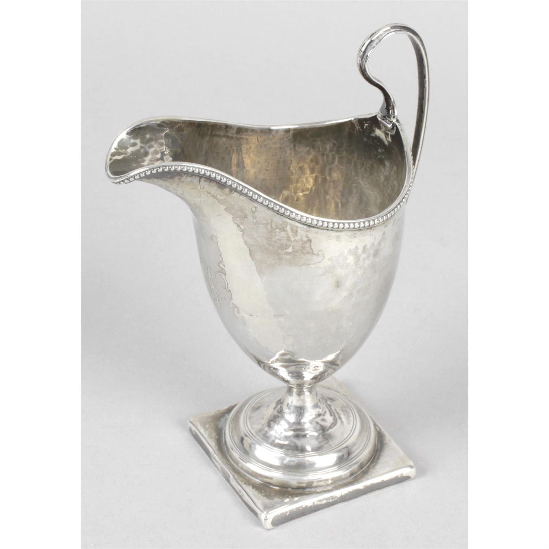 A George III silver helmet shaped cream jug.