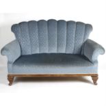 An Early 20th century blue fabric upholstered two seater high back settee, four mahogany framed