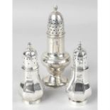 A late Victorian silver pepper pot, together with a pair of 1930's silver pepper pots.