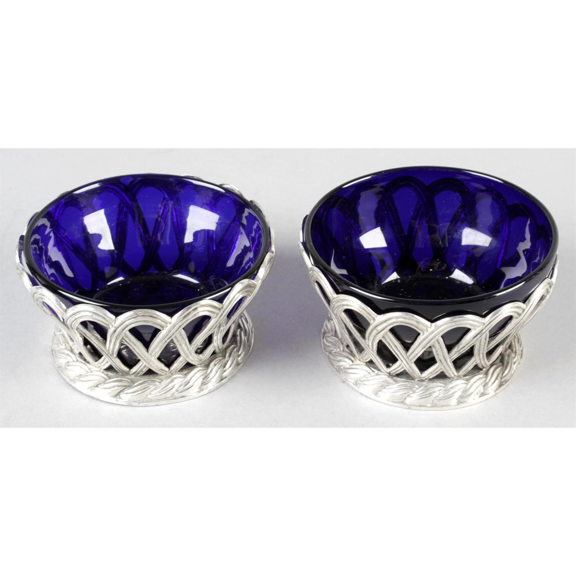 A pair of Victorian silver pierced dishes with blue glass liners.