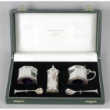 A modern silver three piece condiment set, in fitted case.