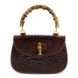 GUCCI - a brown crocodile handbag with bamboo closer.