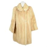 A blonde mid length mink fur coat.