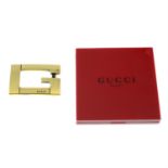 GUCCI - a G belt buckle and a red compact.