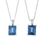 Two blue topaz pendants, suspended from chains.