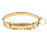 A 9ct gold hinge bangle with scalloped edge detail.
