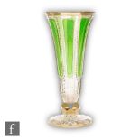 A 19th Century Bohemian glass vase of footed trumpet form, the body faceted with padded green panels