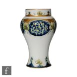 An early 20th Century William Moorcroft Lilac pattern baluster vase decorated with panels of flowers