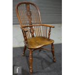 A 19th century yew wood and elm Windsor elbow chair with pieced vase splat on splayed turned legs