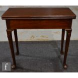 A George III mahogany fold-over tea table, with plain apron and husk carved knees over pad feet,
