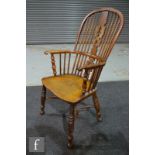 A 19th century yew wood and elm seat Windsor elbow chair, pierced splat on turned legs united by a