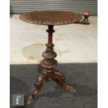 A Victorian walnut sewing table of circular form, with a foliate carved outer border and rotating