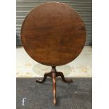 A 19th Century mahogany snap-top supper table of circular form, raised to a turned pedestal