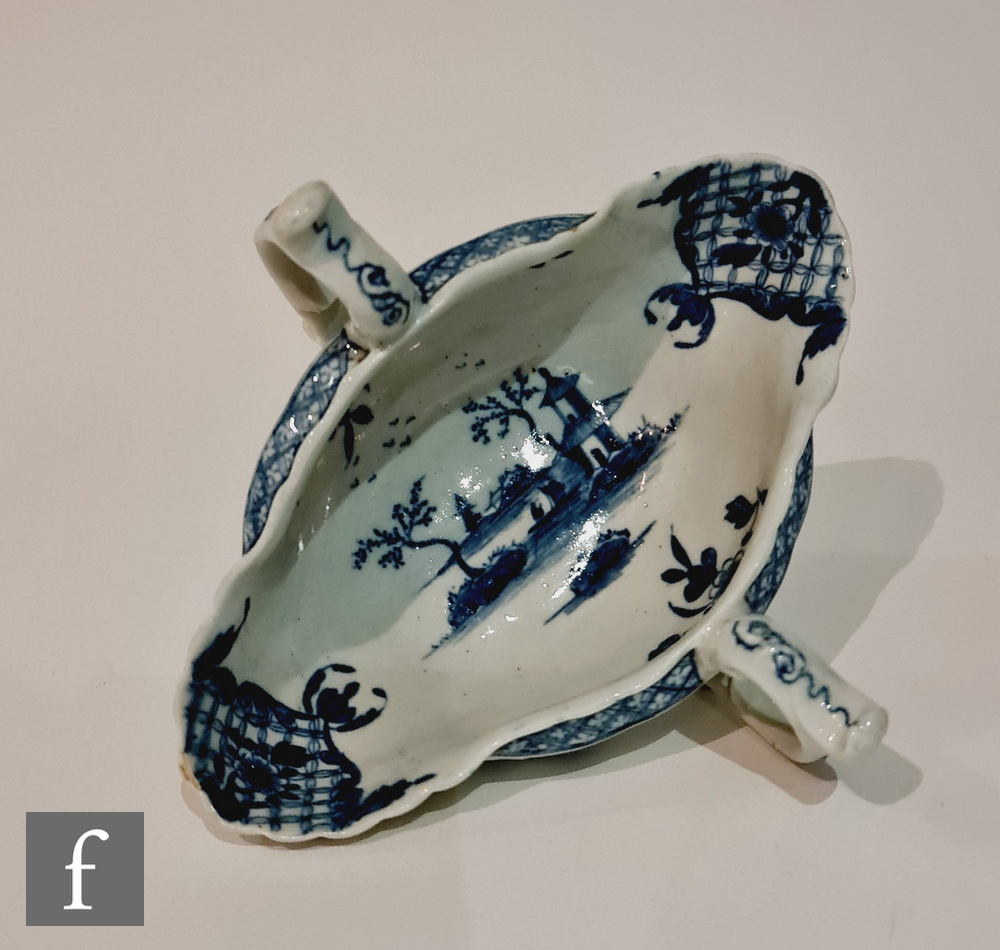 A late 18th Century Worcester twin handled sauce boat decorated with a blue and white hand painted