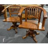 A pair of reproduction captain's swivel chairs, with reeded lath backs over conforming reeded bases.
