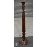 A 19th Century converted torchere of turned reeded pedestal form on a circular base and brass paw