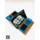A part 1960s cutlery set in teak and part ebonised carrying case, width 29cm.