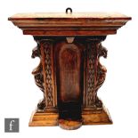 A 19th century and later carved walnut votive stand, the recessed interior flanked by a pair of