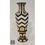 A late 19th Century Bohemian vase of footed baluster form, cased in white over green and cut with