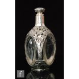 A continental glass bottle of dimpled tri-form, cased in a silver reticulated mount decorated with