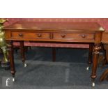 A Victorian mahogany two drawer writing table, the plain top over two frieze moulded edge front
