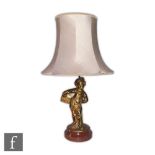 A 20th Century French gilt bronze table lamp modeled as a young boy wearing a cap and holding a